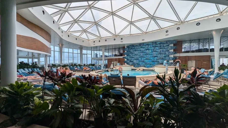 A glass-domed solarium pool deck aboard a cruise ship