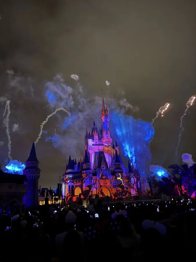 Fireworks bursting over Cinderella Castle at night